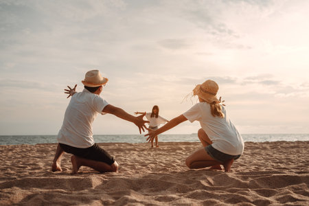 Happy asian family enjoy the sea beach at consisting father, mother and daughter having fun playing beach in summer vacation on the ocean beach. Happy family with vacations time lifestyle concept.の写真素材