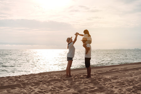 Happy asian family enjoy the sea beach at consisting father, mother and daughter having fun playing beach in summer vacation on the ocean beach. Happy family with vacations time lifestyle concept.の写真素材