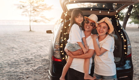 Happy Family with car travel and camping road trip. summer vacation in car in the sunset, Dad, mom and daughter happy traveling enjoy together driving in holidays, people lifestyle ride by automobile.の写真素材