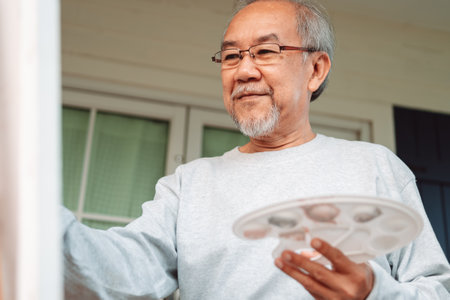 Asian caregiver helping senior male from falling on the ground. Older elderly man patient having accident heart attack when physical therapy. Nurse assistance rescue concept.の写真素材
