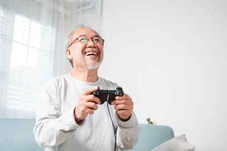 Asian Senior oider man family having fun enjoying play video game funny video using at home sit on sofa. Happiness lifestyle on retirement concepts.の写真素材