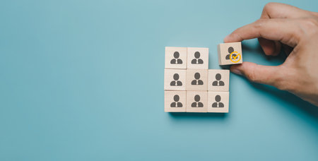 HRM or Human Resource Management, Hand selective and accept to manager icon on wood block which is among staff icons for human development recruitment leadership and customer target group concept.の写真素材