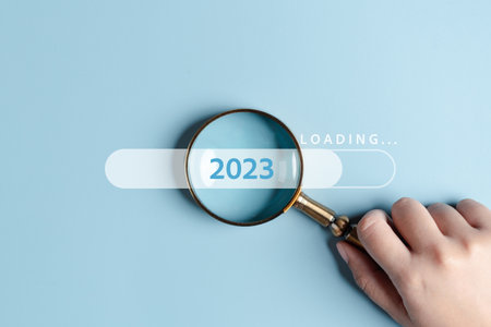 Magnifying glass focus to loading progress 2023 to countdown merry christmas and happy new year concept.の写真素材