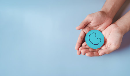 Hands holding blue happy smile face, good feedback rating, positive customer review, experience,...