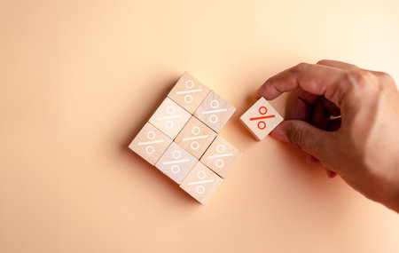Percentage sign of hand arranging wood blocks stacking as step stair with percent symbol,  interest...