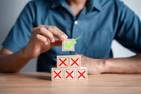 Businessman stacking green correct icon which among wrong icon on wooden block for document and...