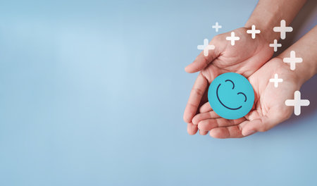 Hands holding blue happy smile face, good feedback rating, positive customer review, experience,...
