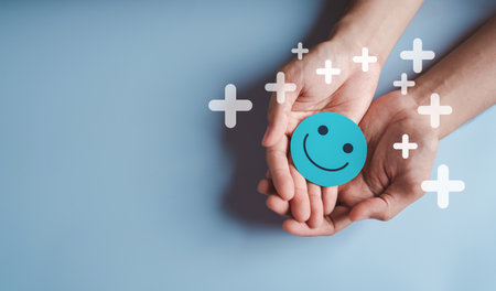 Hands holding blue happy smile face, good feedback rating, positive customer review, experience,...