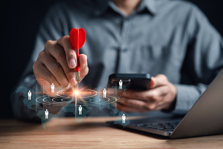 Businessman aiming red arrow dart to business target strategy dartboard for business investment planning development leadership and customer target group.の写真素材