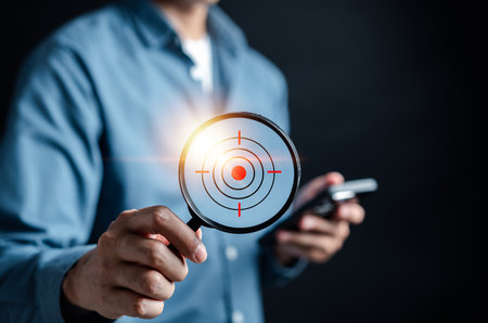 Businessman hand holding Magnifier glass focus to target icon which for planning development leadership and customer target group concept.の写真素材