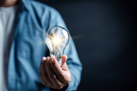 Hand man holding illuminated lightbulb, idea, innovation and inspiration with glowing virtual brain, smart intelligent creativity with bulbs, Motivation and innovation concept.の写真素材