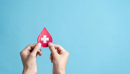 hands holding blood drop paper cut, blood transfusion, world blood donor day, red cross to give blood.world hemophilia day conceptの写真素材
