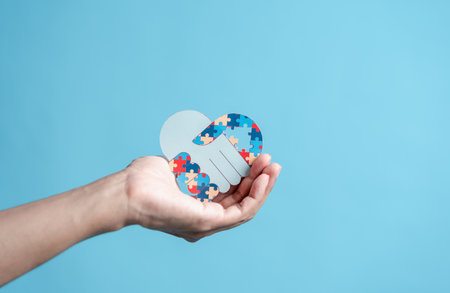 People hand holding jigsaw puzzle, Color puzzle symbol of awareness for autism spectrum disorder family support. Autism World Awareness Day.の写真素材