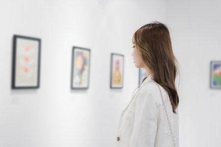 Woman visiting art gallery her looking pictures on wall watching photo frame painting at artwork museum people lifestyle concept.の写真素材