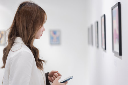 Woman visiting art gallery her looking pictures on wall watching photo frame painting at artwork museum people lifestyle concept.の写真素材