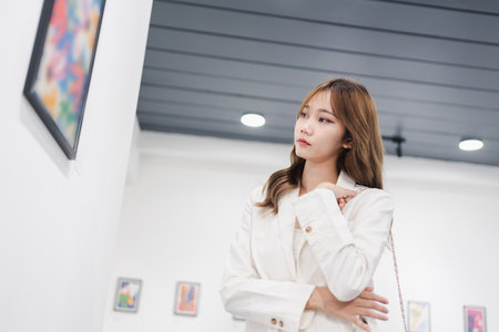 Woman visiting art gallery her looking pictures on wall watching photo frame painting at artwork museum people lifestyle concept.の写真素材