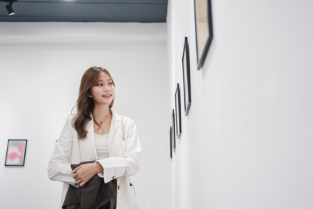 Woman visiting art gallery her looking pictures on wall watching photo frame painting at artwork museum people lifestyle concept.の写真素材