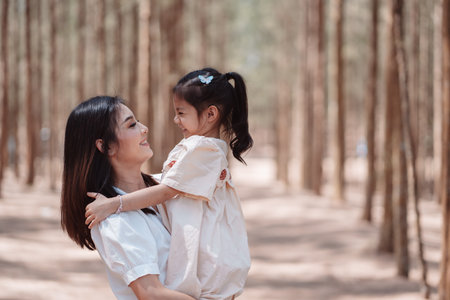 Happy family mother cute daughter enjoying love emotion together on grassy field in forest.の写真素材