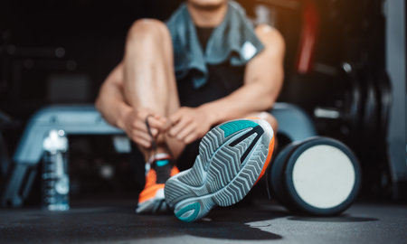 Man exercise workout in gym fitness breaking and resting after training sport with dumbbells and water bottle healthy lifestyle bodybuilding.の写真素材