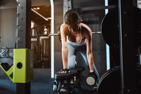 Women working out with weights training exercise lifting dumbbells at fitness gym. Fitness muscular body weight loss. Bodybuilding healthy lifestyle.の写真素材