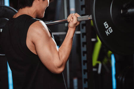Male working out Bodybuilder with barbell weights at the gym.man bodybuilder doing exercises with barbell. training sport healthy lifestyle bodybuilding, Athlete builder muscles lifestyle.の写真素材