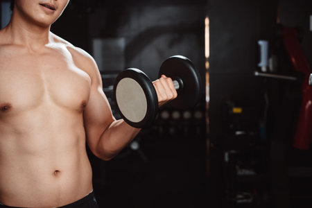 Male working out Bodybuilder with dumbbell weights at the gym.man bodybuilder doing exercises with dumbbell. training sport healthy lifestyle bodybuilding, Athlete builder muscles lifestyle.の写真素材