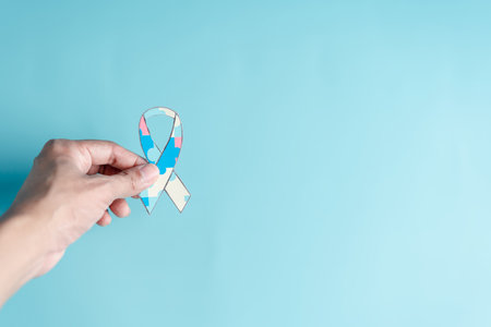Hand holding ribbon jigsaw puzzle, Color puzzle symbol of awareness for autism spectrum disorder family support. Autism World Awareness Day.の写真素材