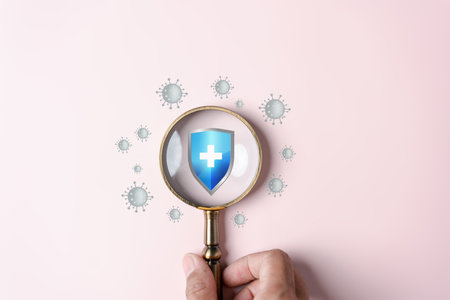 Hand holding magnifier focus to protection shield anti virus and bacteria, Health care secure concept.の写真素材