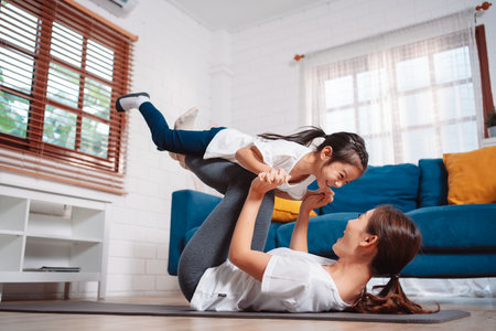 Mother and daughter exercising together happily at home. for flexibility build muscle strength, Sport workout training family together concept.の写真素材