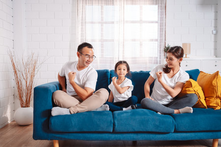 Family consisting of parents and daughters happily exercising together at home. For flexibility, build muscle strength, Sport Workout Training family together.の写真素材