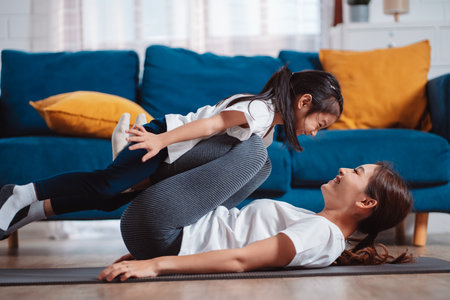 Mother and daughter exercising together happily at home. for flexibility build muscle strength, Sport workout training family together concept.の写真素材