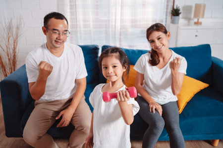 Family consisting of parents and daughters happily exercising together at home. For flexibility, build muscle strength, Sport Workout Training family together.の写真素材