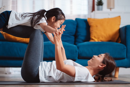 Mother and daughter exercising together happily at home. for flexibility build muscle strength, Sport workout training family together concept.の写真素材