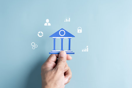 Hand Holding Bank Government building paper cut out, Transaction and banking current financial concept.の写真素材