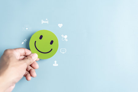 Hands holding green happy smile face. mental health positive thinking and growth mindset concept.の写真素材
