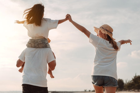 Happy asian family enjoy the sea beach. father, mother and daughter having fun playing beach in summer vacation on the ocean beach. Happy family with vacation time lifestyle concept.の写真素材