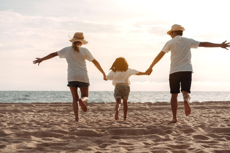 Happy asian family enjoy the sea beach. father, mother and daughter having fun playing beach in summer vacation on the ocean beach. Happy family with vacation time lifestyle concept.の写真素材