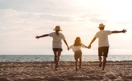 Happy asian family enjoy the sea beach. father, mother and daughter having fun playing beach in summer vacation on the ocean beach. Happy family with vacation time lifestyle concept.の写真素材
