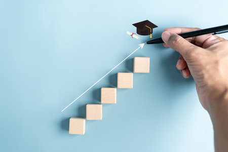 Steps of education leading to success goal. Taking strategic steps towards graduation. Career path and first for business, Graduation achievement goals concept. Graduation cap on wooden block.の写真素材