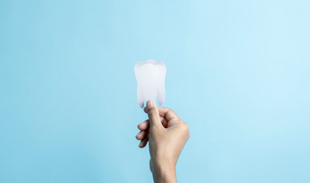 Hand holding Dental white teeth inside examined dentist check-up technology health care conceptの写真素材