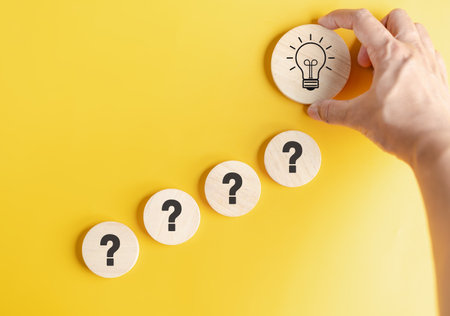 Hand hold wood block to smart creativity light bulb which among question icon. smart, creative, idea...