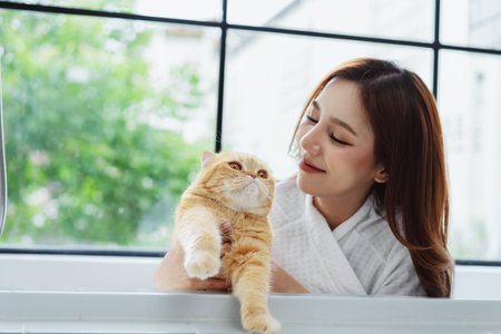 Happy Asian woman owner cute cat playful in a home. Friendship of pet and human people lifestyle.の写真素材