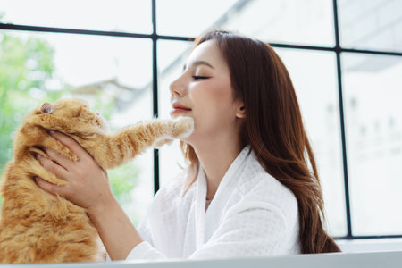 Happy Asian woman owner cute cat playful in a home. Friendship of pet and human people lifestyle.の写真素材