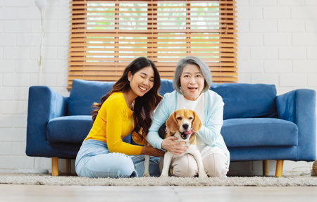 Happy asian senior woman retirement and daughter enjoying her dog pet in the home, Friendship pet and human lifestyle concept.の写真素材