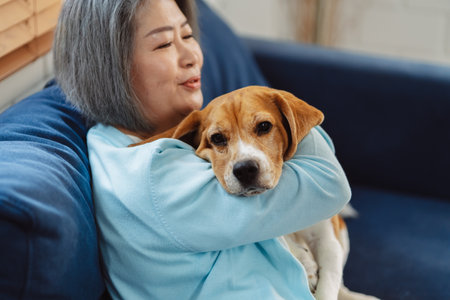 Happy asian senior woman retirement enjoying her dog pet in the home, Friendship pet and human lifestyle concept.の写真素材