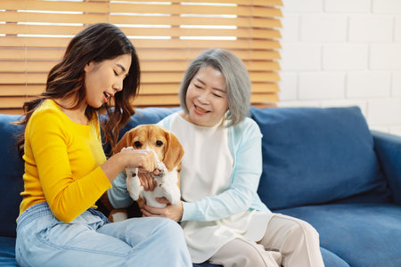 Happy asian senior woman retirement and daughter enjoying her dog pet in the home, Friendship pet and human lifestyle concept.の写真素材
