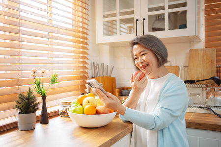 Happy Asian senior woman eating clean food for healthy eating in the kitchen room, Health care concept.の写真素材