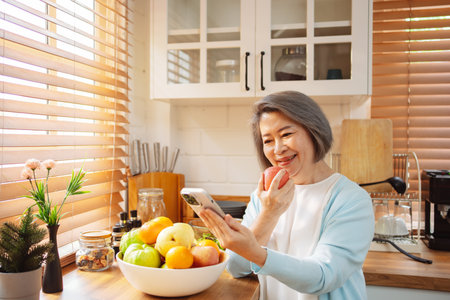 Happy Asian senior woman eating clean food for healthy eating in the kitchen room, Health care concept.の写真素材