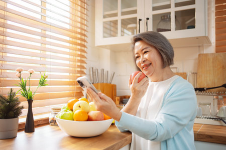 Happy Asian senior woman eating clean food for healthy eating in the kitchen room, Health care concept.の写真素材
