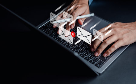 Businessman sending email by laptop computer to customer, business contact and communication, email icon, email marketing conceptの写真素材